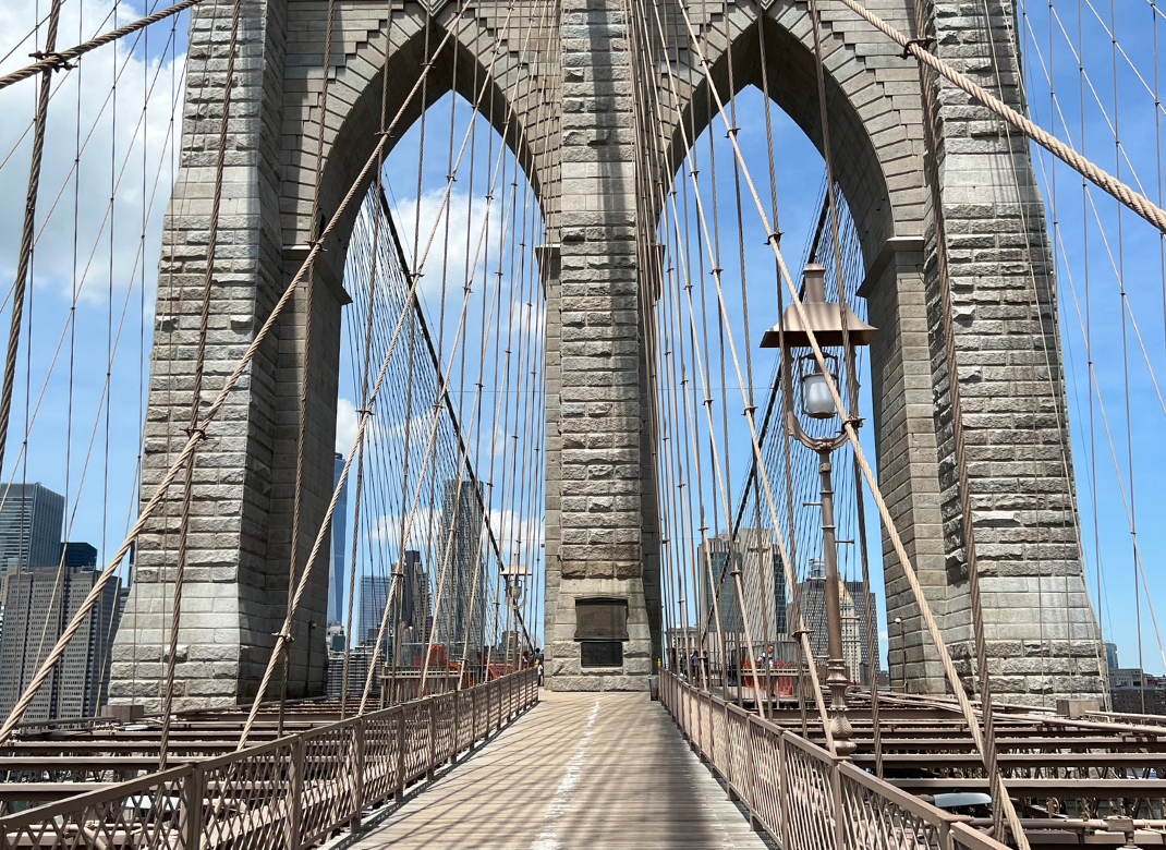Die ikonische Brooklyn Bridge in New York City, die sich über den East River spannt, mit Manhattan im Hintergrund.
