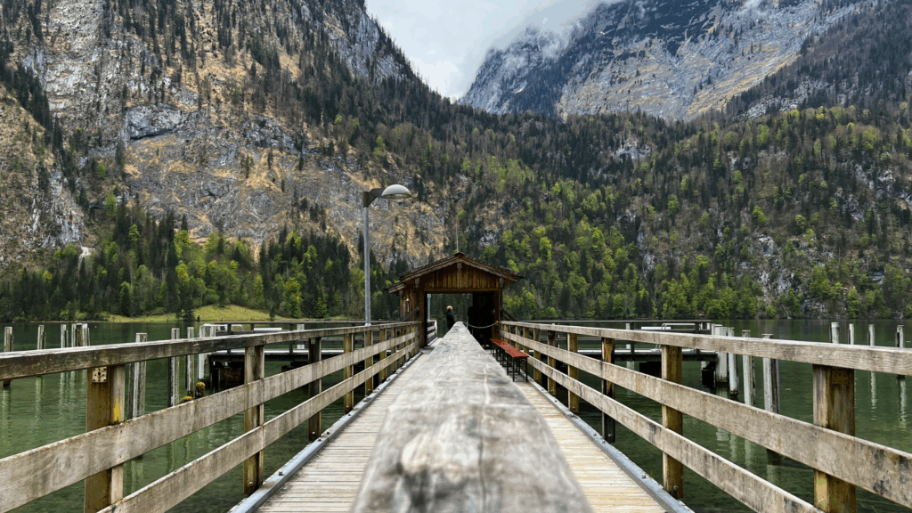 Holzsteg am Königssee mit überdachter Anlegestelle vor imposanter Bergkulisse im Berchtesgadener Land