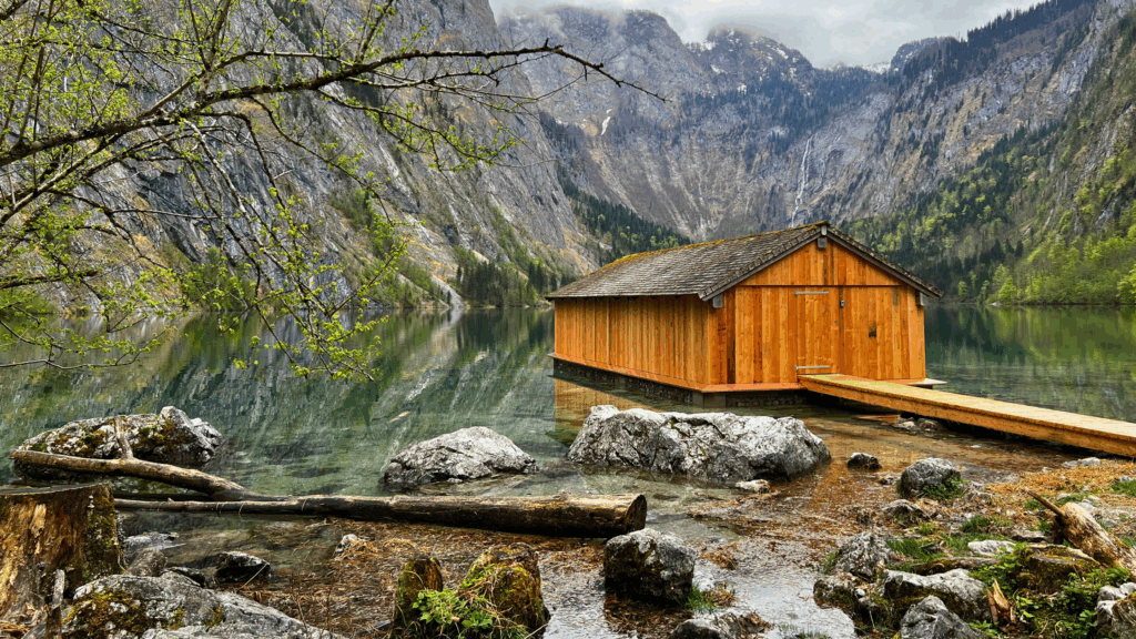Holzboothütte am Obersee im Nationalpark Berchtesgaden mit glasklarem Wasser und beeindruckender Bergkulisse